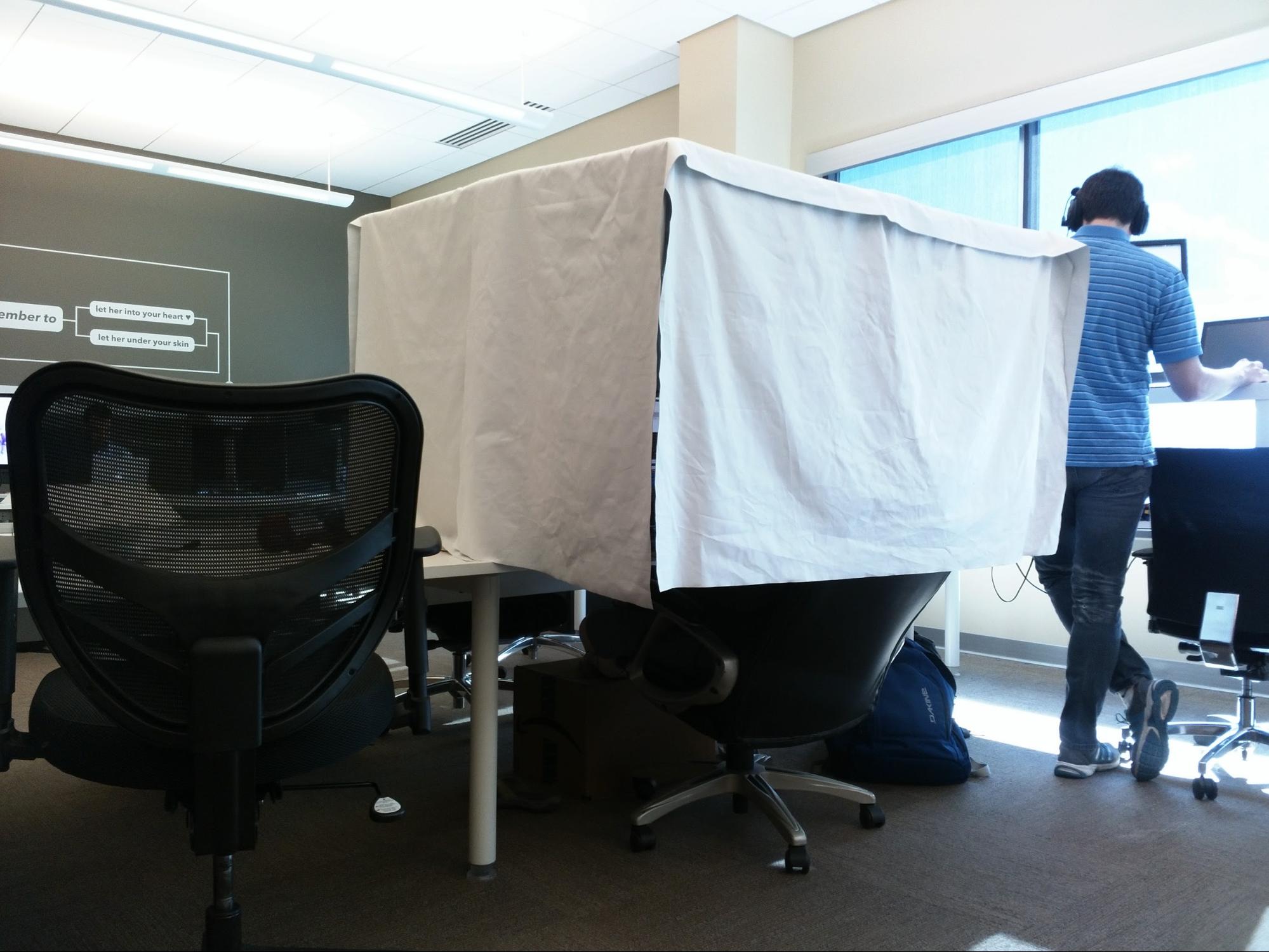 A cloth tent built around a workplace.